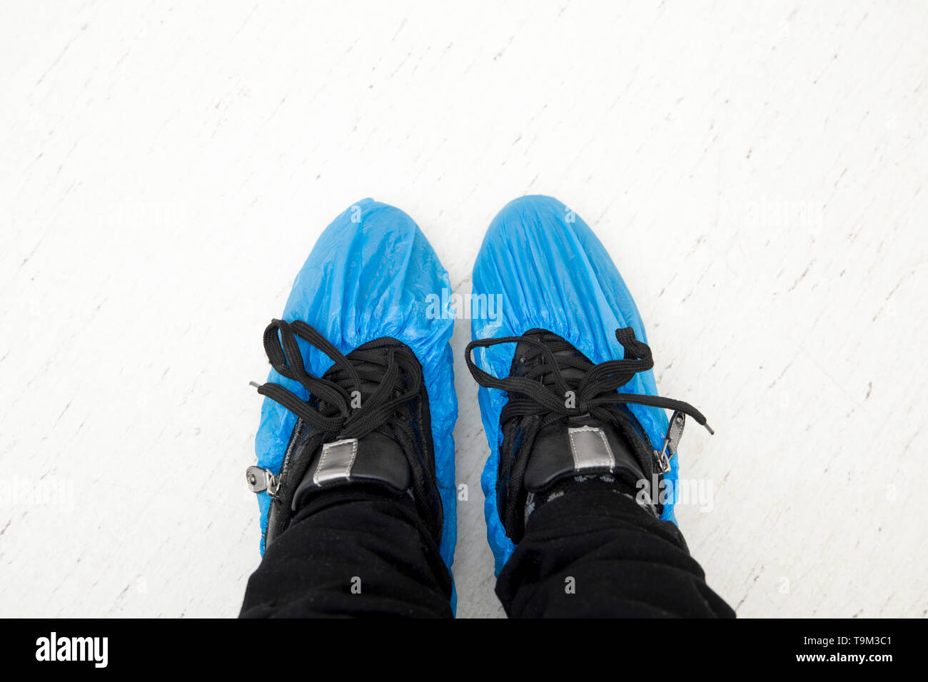 Top view of person`s feet shoes wearing medical antibacterial blue